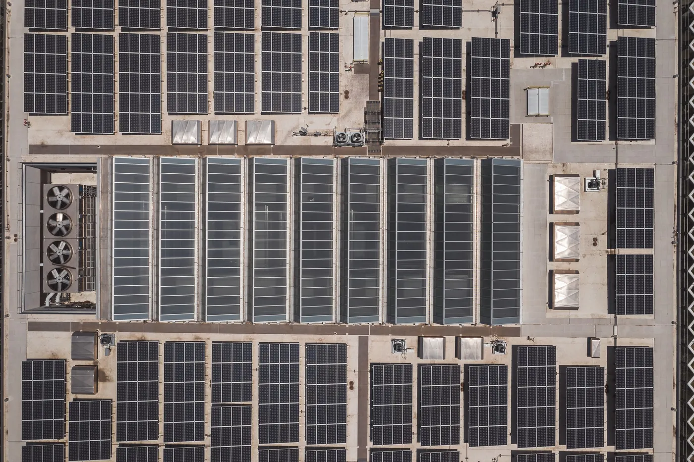 Aerial view of a commercial rooftop covered in solar panels