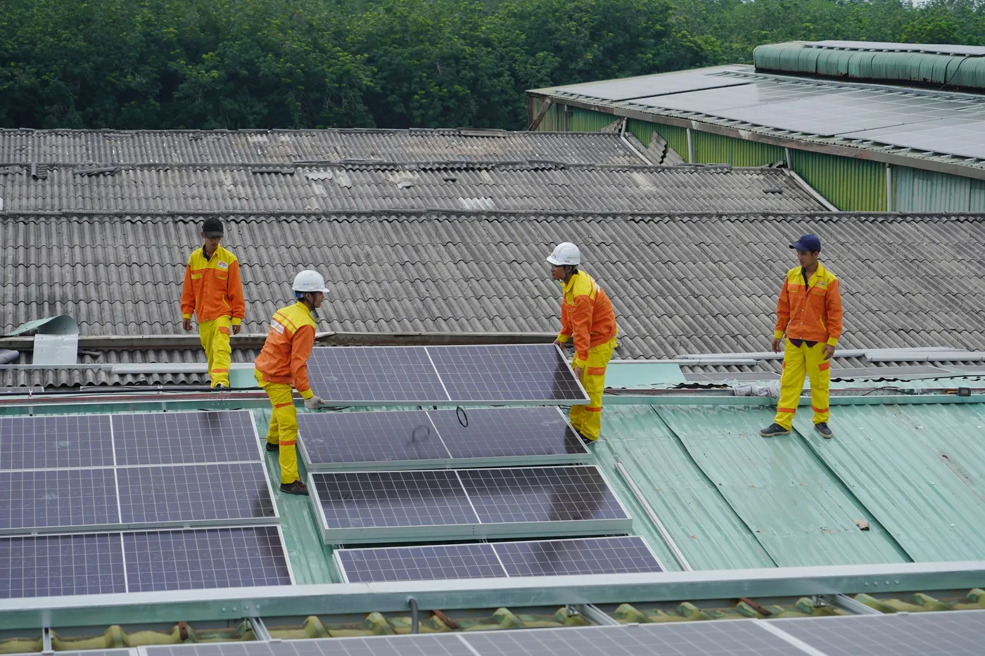 Installation crew fitting solar panels on a metal roof